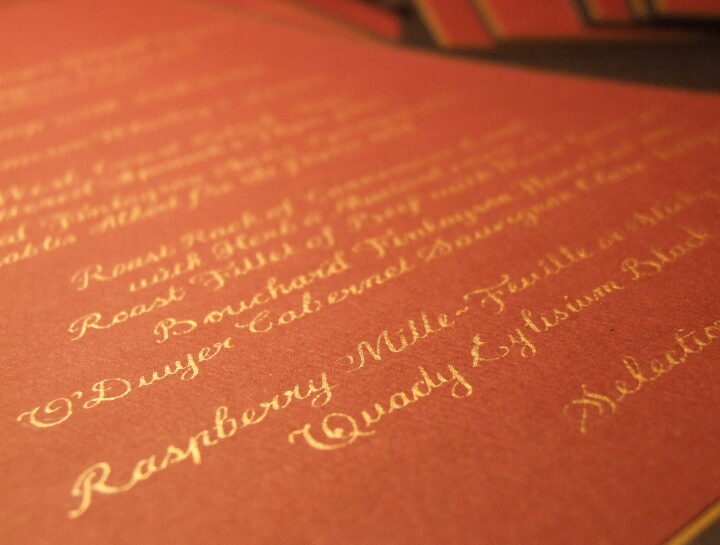 A stunning hand-lettered anniversary dinner menu by Jagdeep Sahans of Soul Scribe Calligraphy. Exquisite gold ink on vibrant magenta paper creates pure elegance.