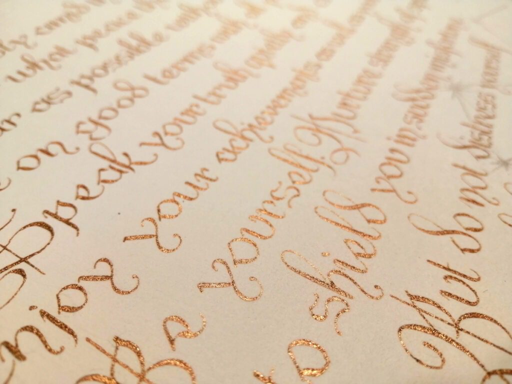 Extract from Desiderata by Max Ehrmann. Close-up of elegant copper cursive handwriting on cream paper. Bespoke calligraphy commission. Calligrapher, Jagdeep Sahans