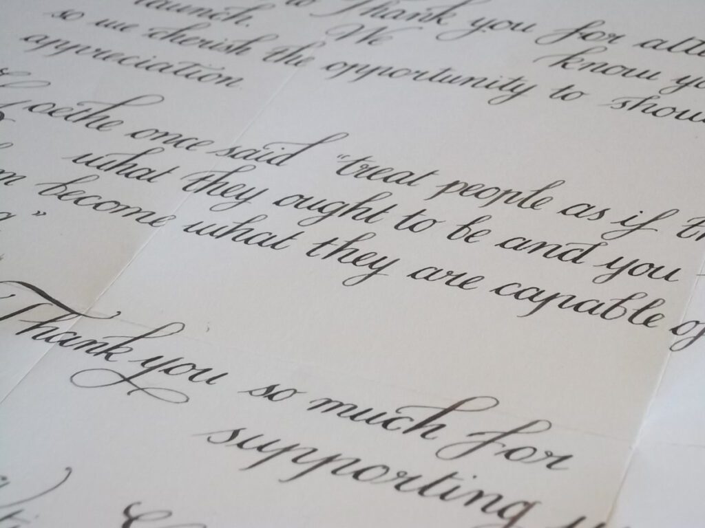 Close-up of black cursive handwriting on cream-colored paper.